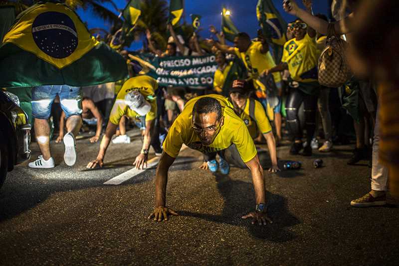 Firande män som gör armhävningar iklädda tröjor med Brasiliens flagga