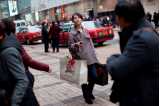 Gatuscen från stad i Asien med kvinna med shoppingkassar.