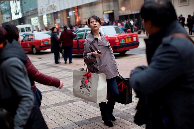 Gatuscen från stad i Asien med kvinna med shoppingkassar.
