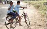 Två pojkar i skoluniform på cykel