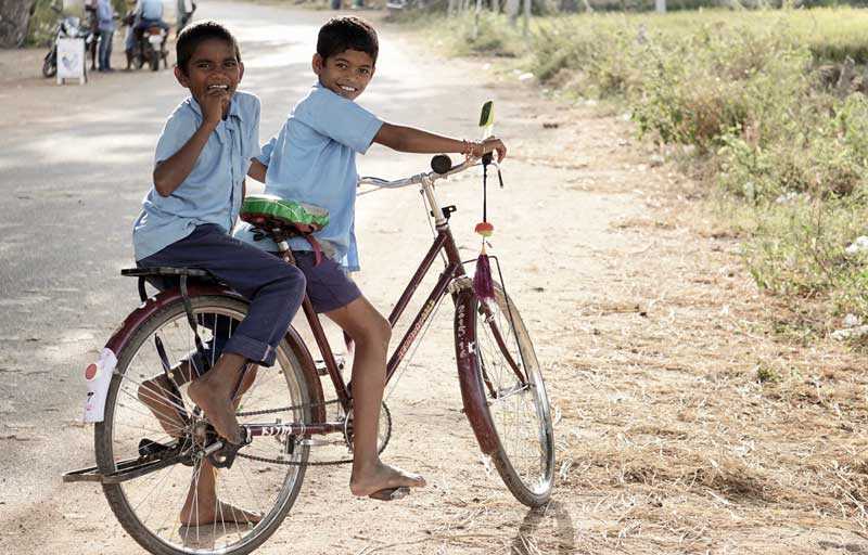 Två pojkar i skoluniform på cykel
