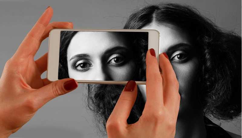 En kvinna blir fotograferad med en smartphone