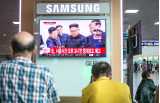 Två män i förgrunden tittar på en tv-skärm med nyheter om Nordkorea.