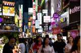 Gående på en gata med neonskyltar i Seoulm Sydkorea