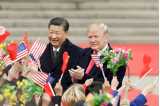 President Jinping och Donald Trump i mörka rockar framför händer med viftande flaggor