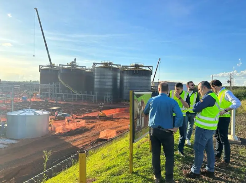 En bild på fem män som överblickar en fabrik.