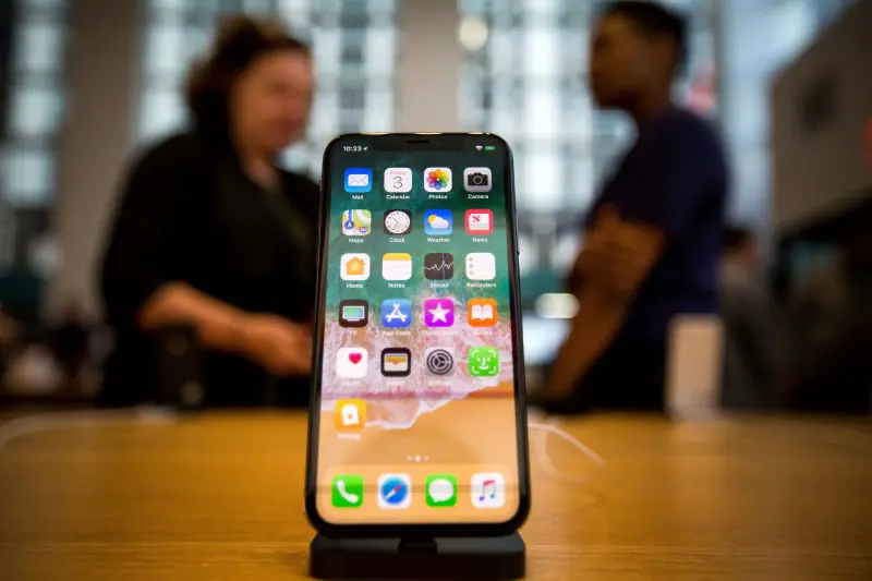 Bilde av en iPhone med to mennesker i bakgrunnen