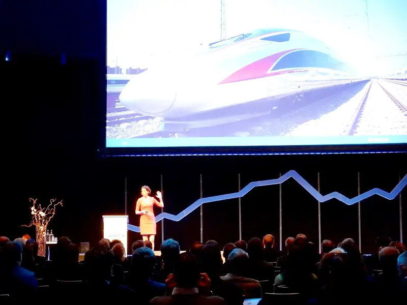 En kvinna på scen framför en presentation